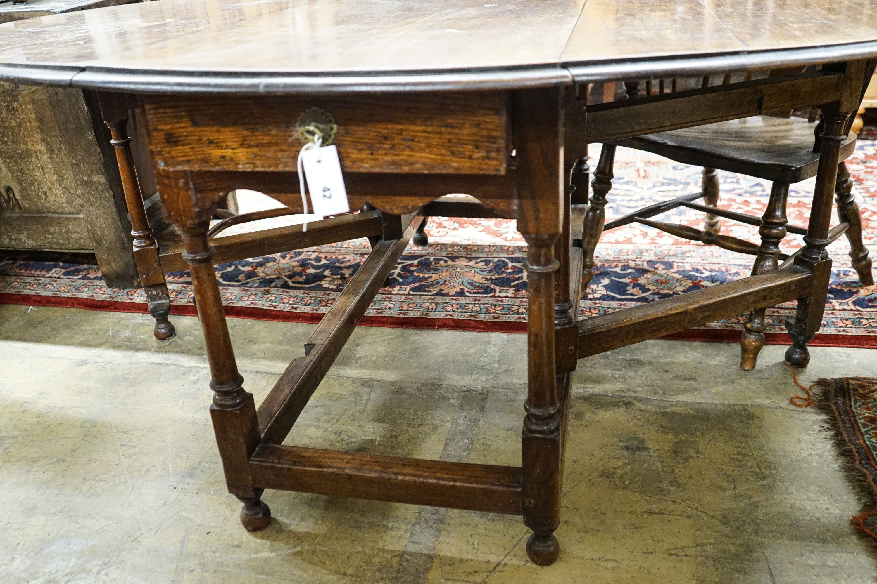 A 17th century style oak gateleg table, with oval top and two frieze drawers, open to 170cm, width 148cm, height 73cm